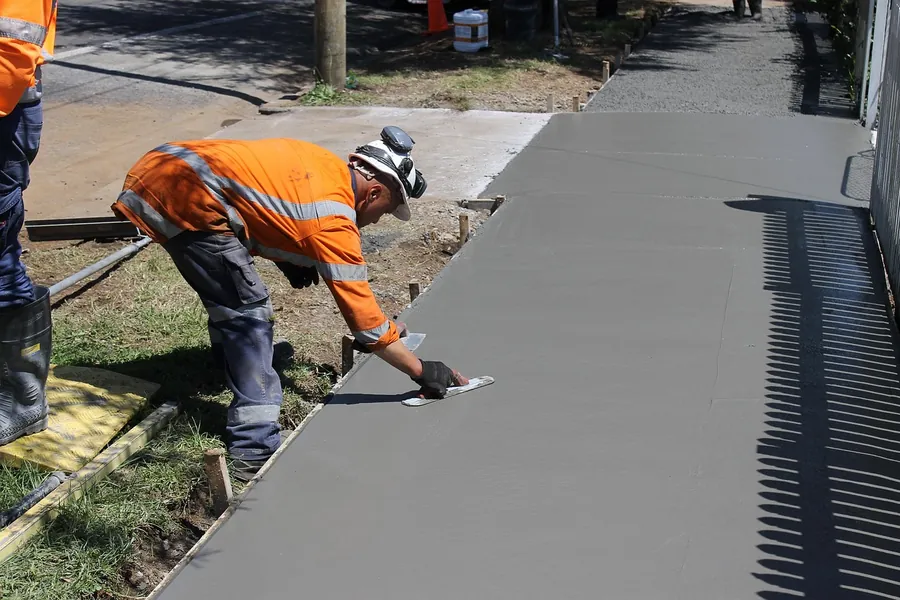 Concrete finisher edging a freshly poured sidewalk, Bartlesville