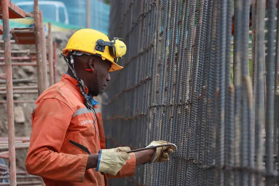Worker in a hard hat tying steel rebar for a concrete wall, Bartlesville